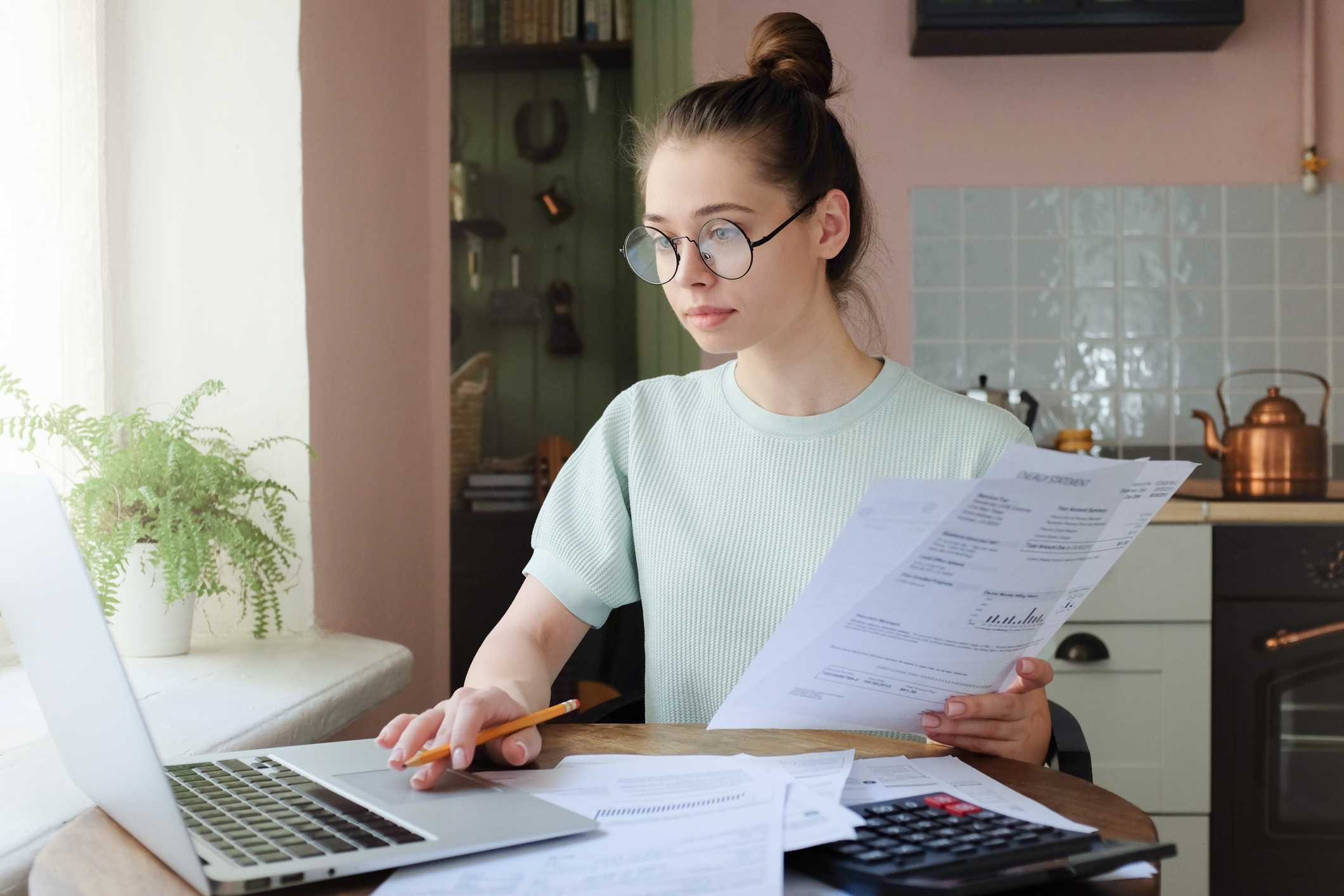 A female student reviews dental education debt management strategies on her laptop as she pursues financial paperwork.